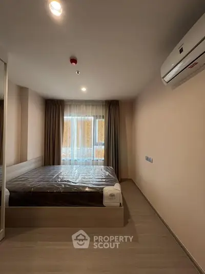 Modern bedroom with sleek design and natural light, featuring air conditioning and stylish curtains.