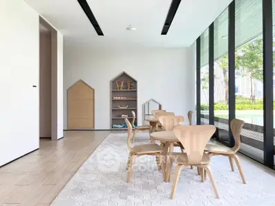 Modern dining area with wooden furniture and large windows overlooking greenery