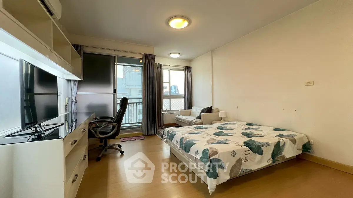 Spacious bedroom with modern decor and balcony access in urban apartment