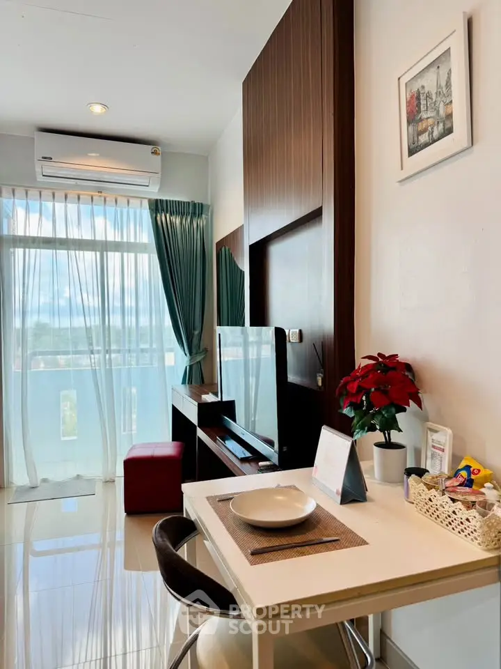 Modern living room with balcony view, sleek furniture, and elegant decor in a bright apartment.