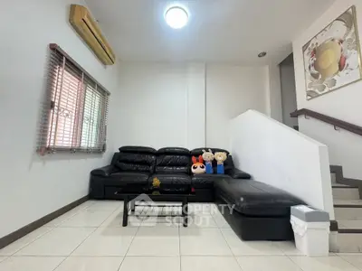 Modern living room with black leather sofa and stylish decor