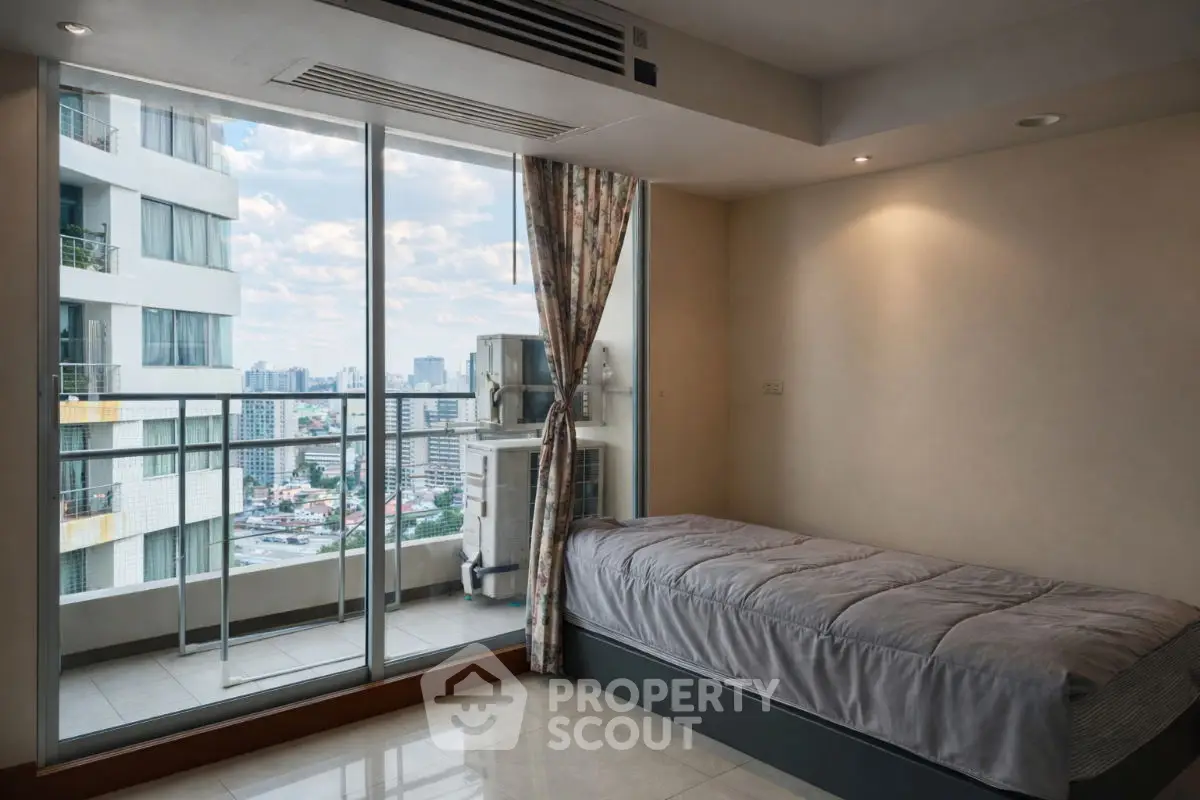 Cozy bedroom with city view and balcony access in modern apartment