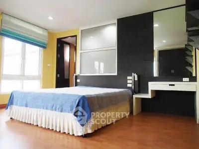 Spacious bedroom with modern decor and natural light in a stylish home.
