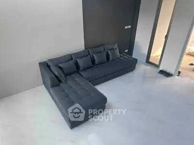 Modern living room with sleek dark sectional sofa and minimalist design