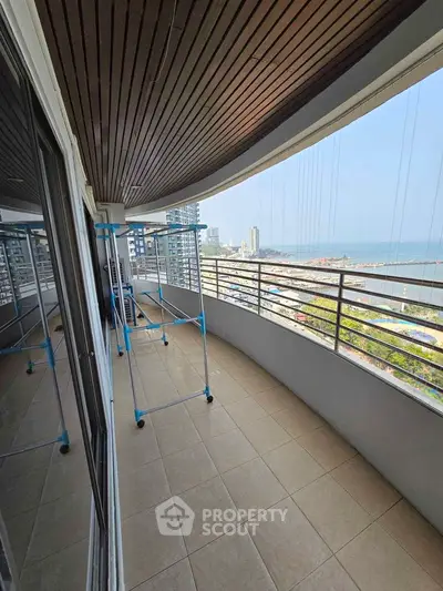 Spacious balcony with stunning ocean view in modern high-rise apartment.