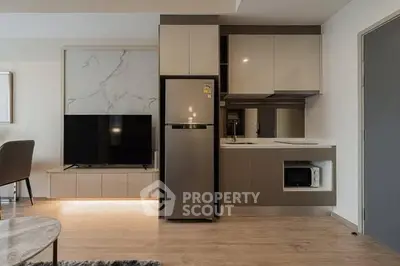 Modern kitchen with sleek cabinetry and stainless steel appliances in a stylish apartment.