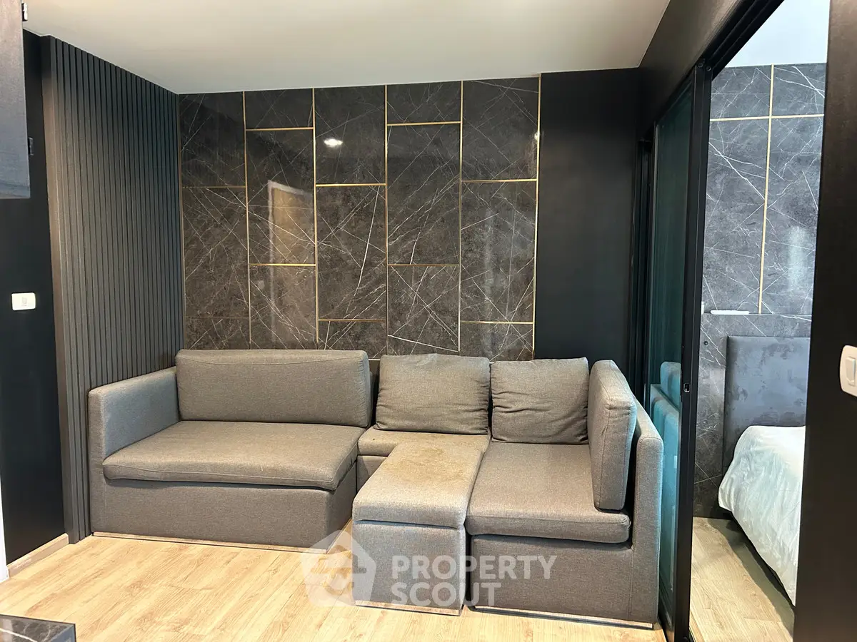 Modern living room with stylish gray sofa and elegant wall design