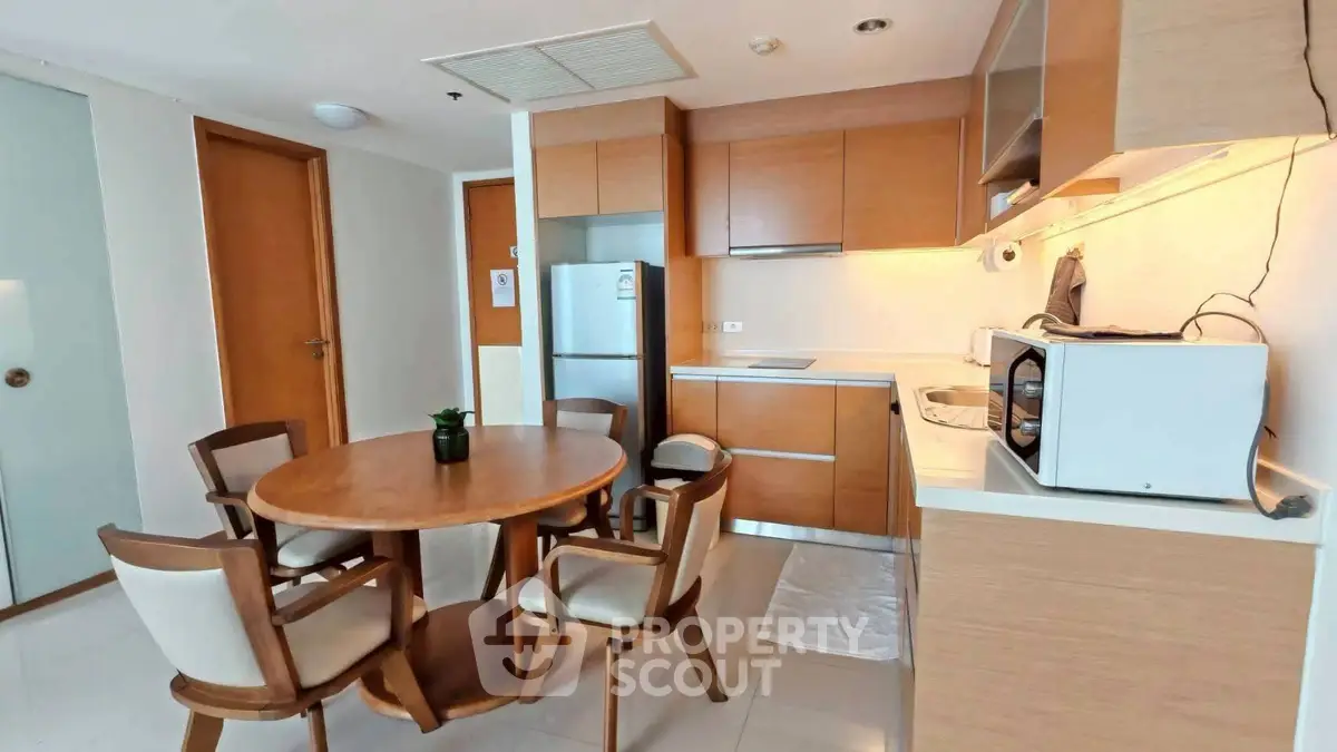 Modern kitchen with wooden dining set and sleek appliances in cozy apartment