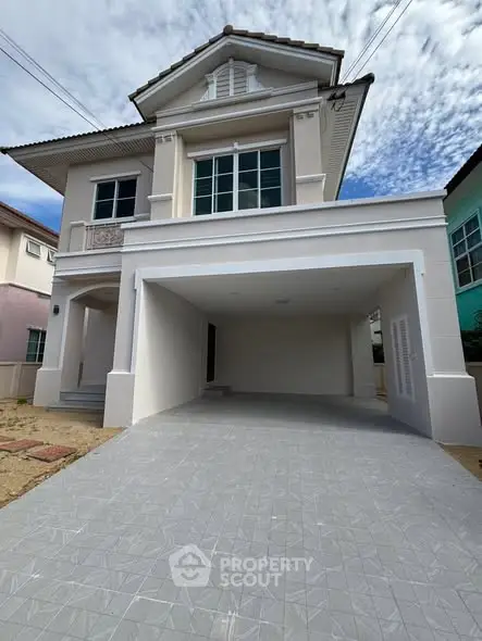 Elegant two-story house with spacious driveway and modern exterior design.