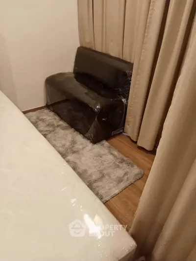 Cozy bedroom corner with plush rug and compact sofa, perfect for relaxation.