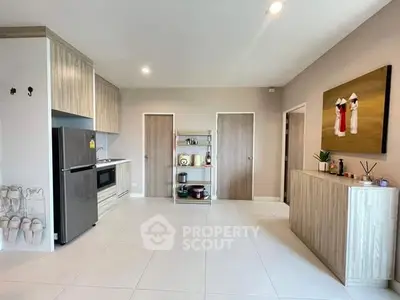 Spacious modern kitchen with sleek cabinetry and stainless steel fridge