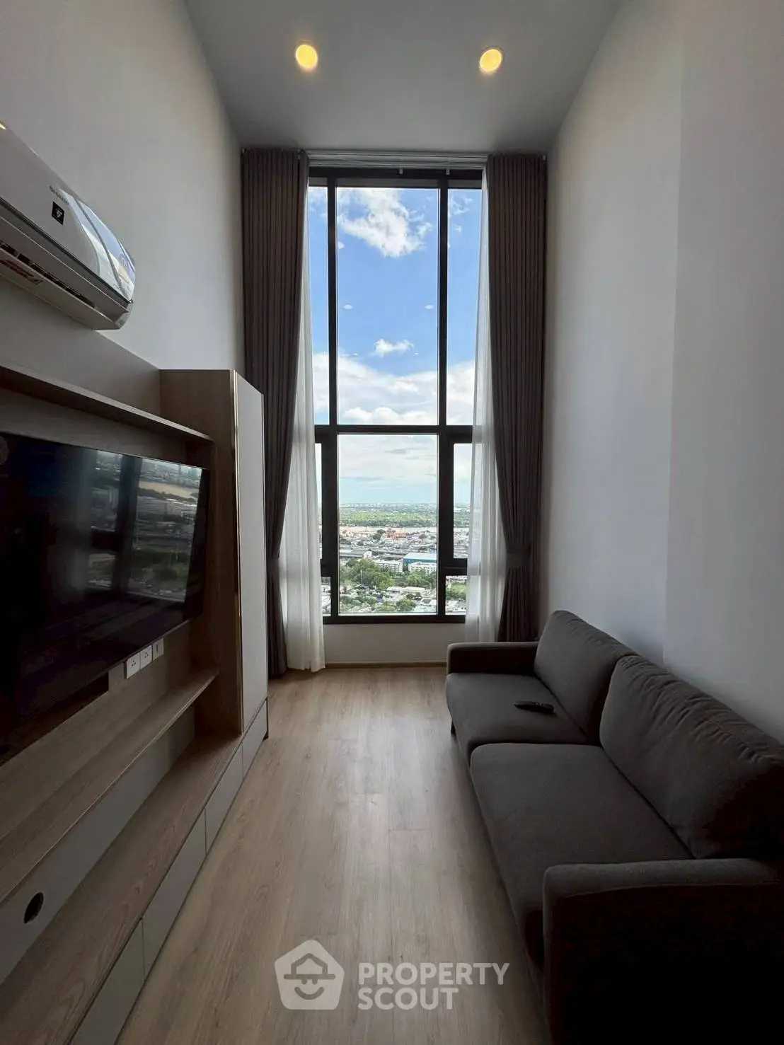 Modern living room with floor-to-ceiling window and stunning city view