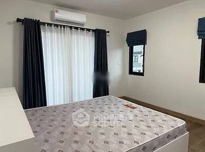 Spacious bedroom with large windows and modern air conditioning unit.