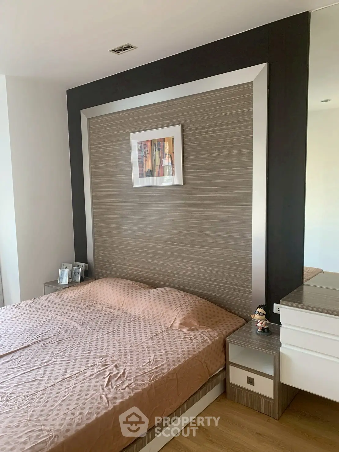 Modern bedroom with stylish headboard and cozy bedding in a contemporary apartment.