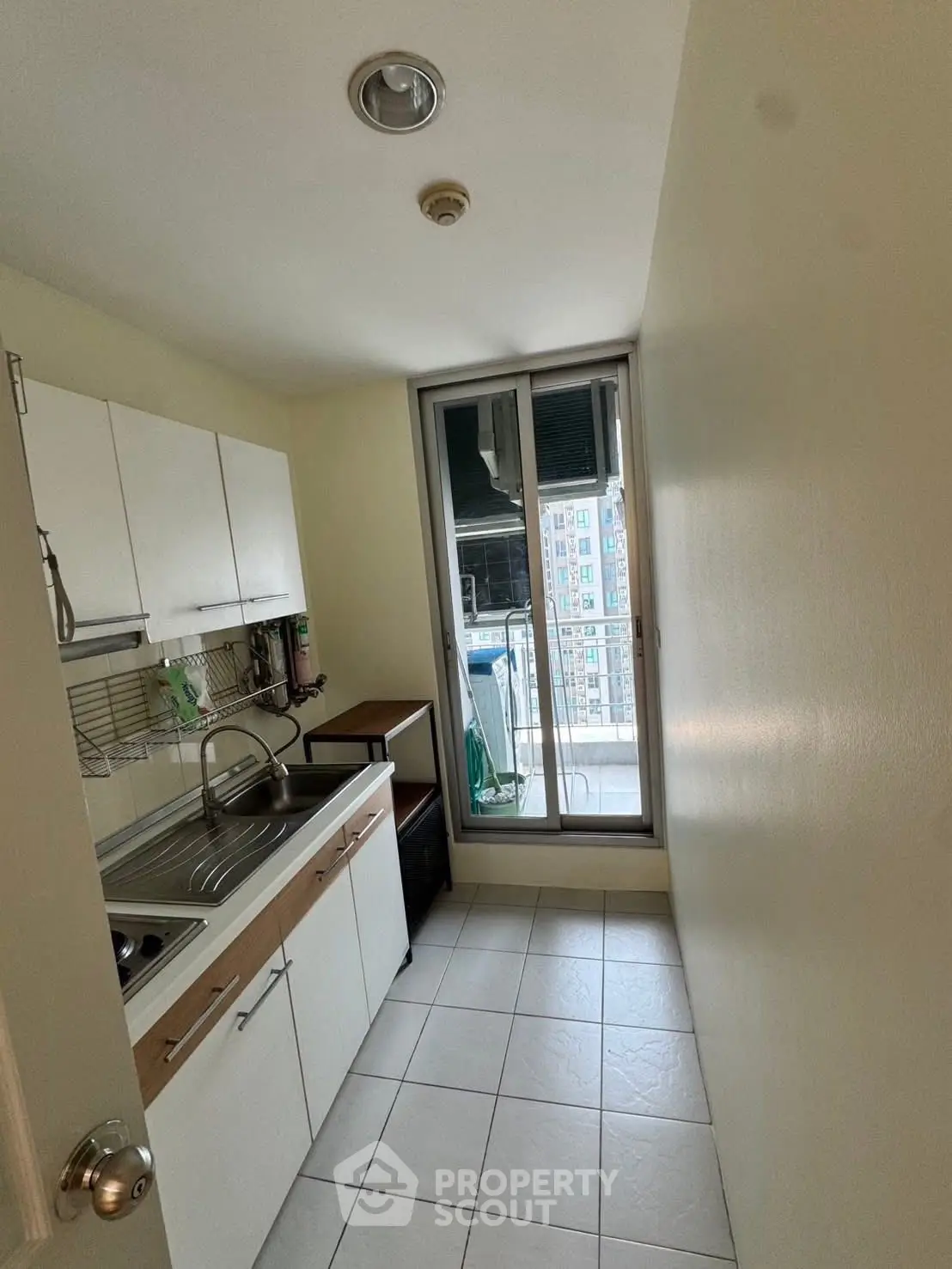 Compact kitchen with balcony access in modern apartment