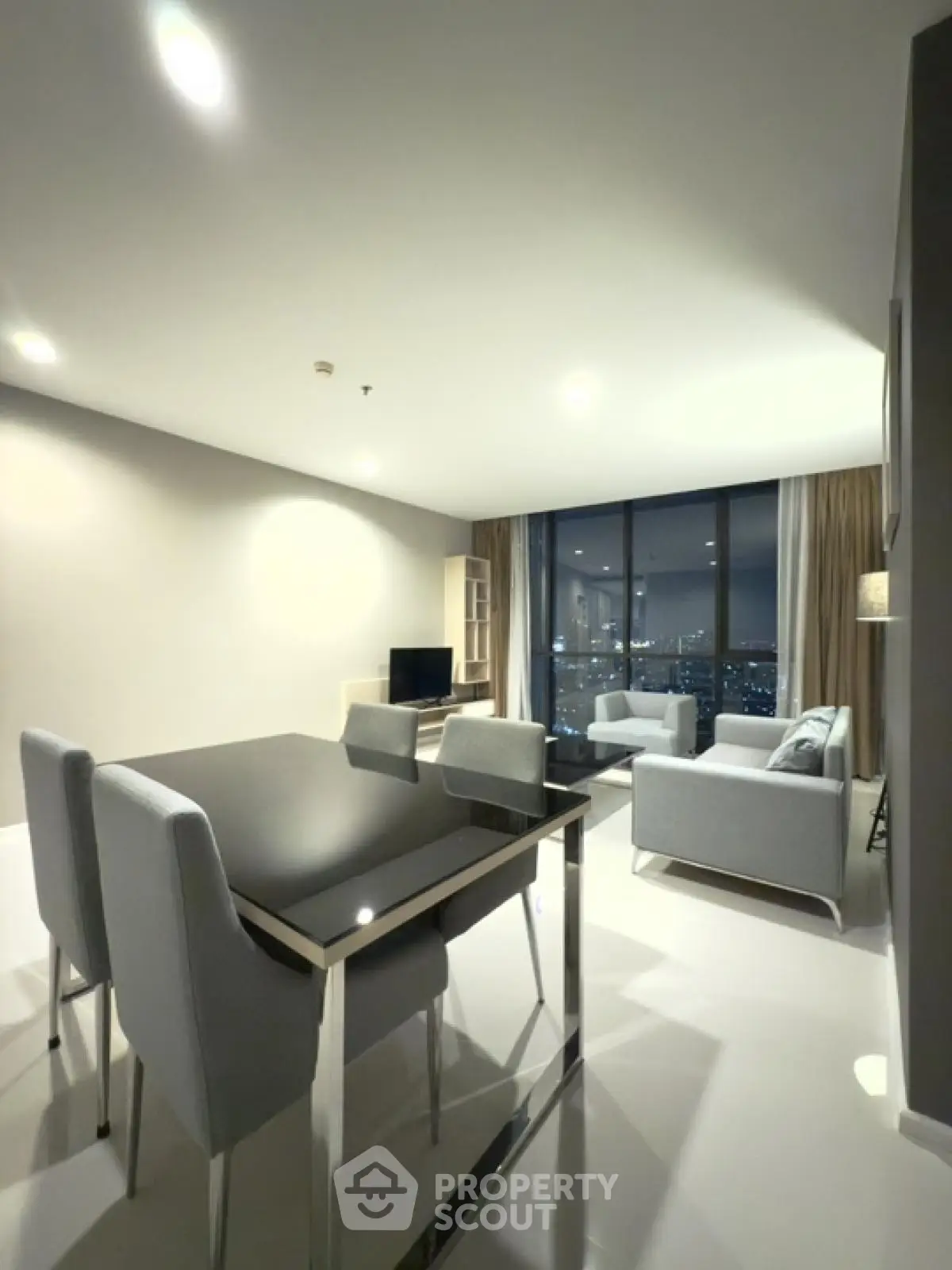 Modern living room with city view, elegant furniture, and sleek dining area