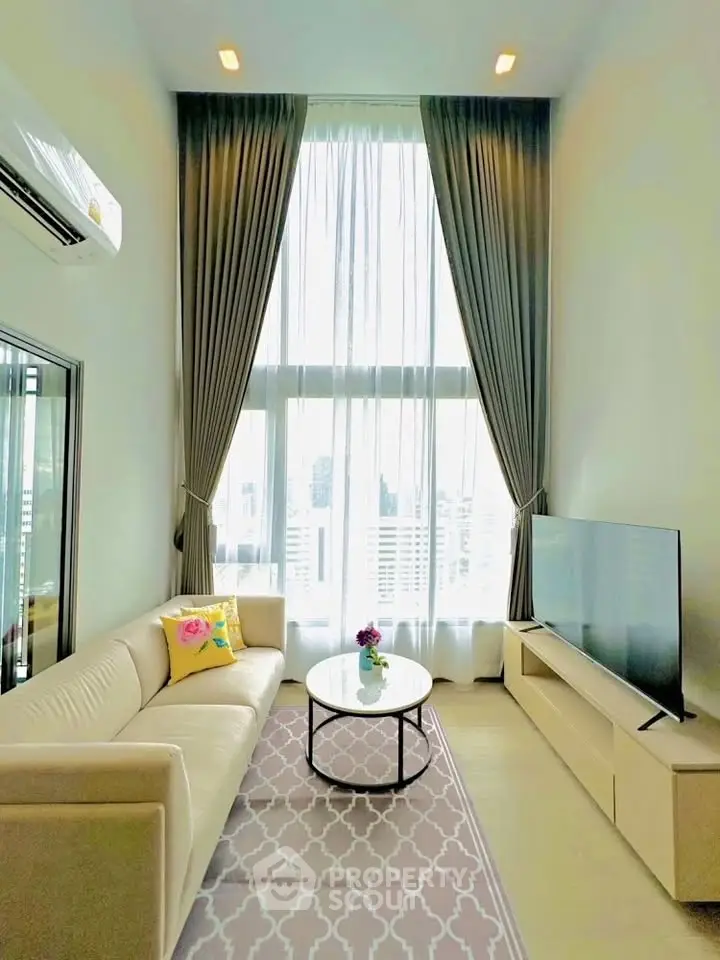 Luxurious high-ceiling living room with elegant decor and large windows offering city views.