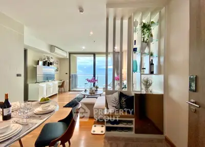 Luxurious open-plan living room with ocean view, modern decor, and elegant dining area.