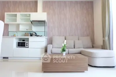 Modern open-layout living room with sleek kitchen and cozy sofa