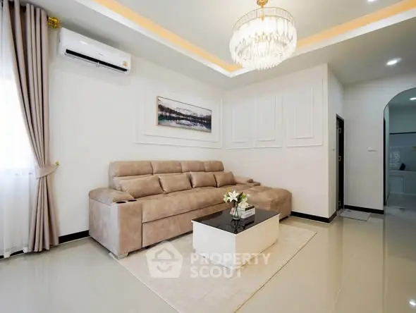 Luxurious living room with elegant chandelier and plush sofa in modern apartment