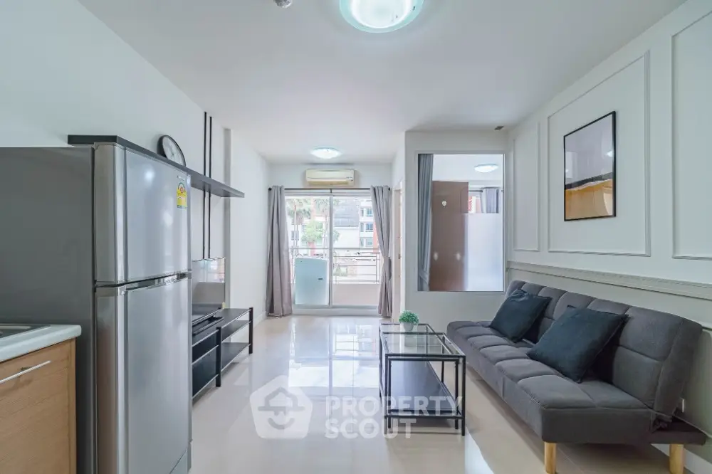Modern living room with sleek furniture and balcony view in a bright apartment.