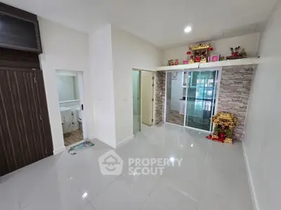 Spacious living room with modern design and sliding glass doors leading to a cozy balcony.