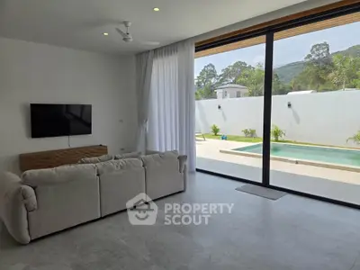 Spacious living room with pool view and modern decor in luxury home