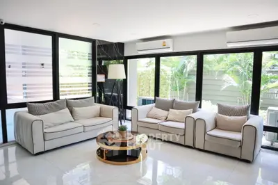 Spacious modern living room with large windows and elegant furniture