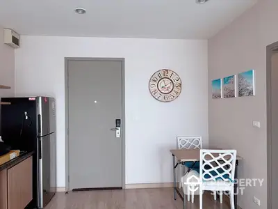 Cozy modern kitchen with sleek black appliances, wooden flooring, and a quaint dining area, perfect for urban living.