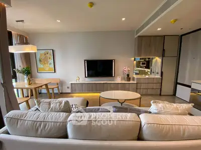 Modern living room with cozy sofa, stylish decor, and open dining area in luxury apartment.