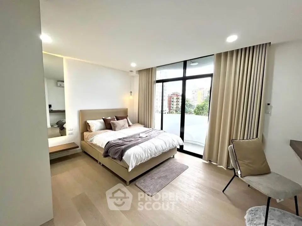 Modern bedroom with large windows and balcony view in a stylish apartment