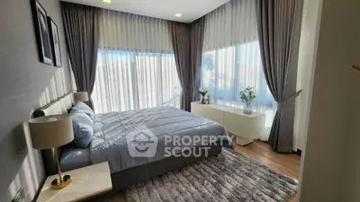 Luxurious bedroom with elegant decor and large windows offering natural light