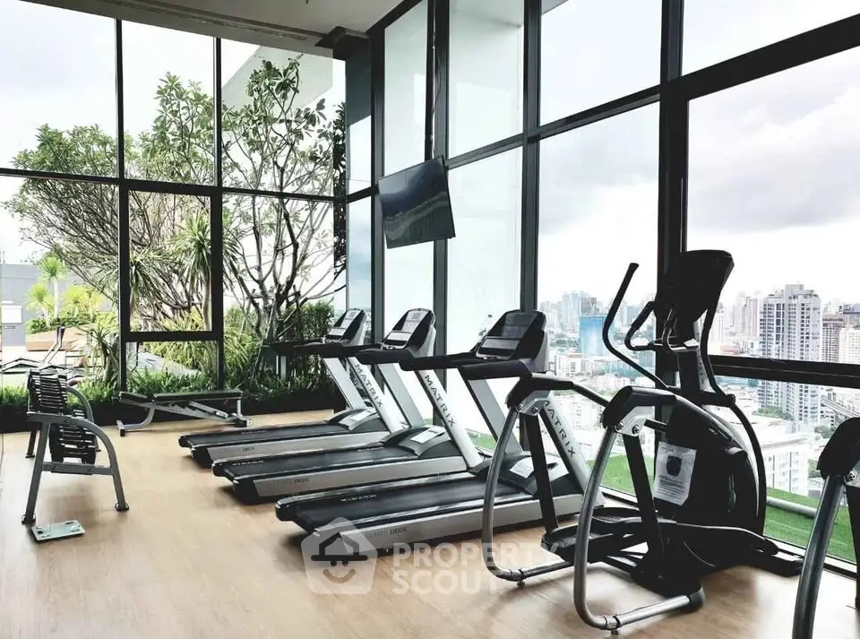 Luxurious high-rise gym with panoramic city views and modern fitness equipment.