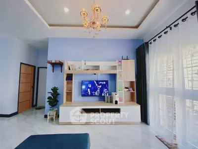 Modern living room with elegant chandelier and entertainment center