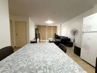 Spacious living room with modern decor and open layout, featuring a dining area and comfortable seating.