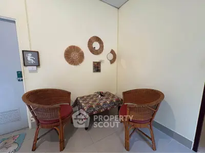 Cozy corner with wicker chairs and decorative wall art in a welcoming living space.