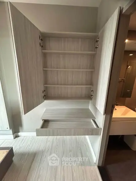 Modern storage cabinet with open shelves and drawer in a sleek interior design.