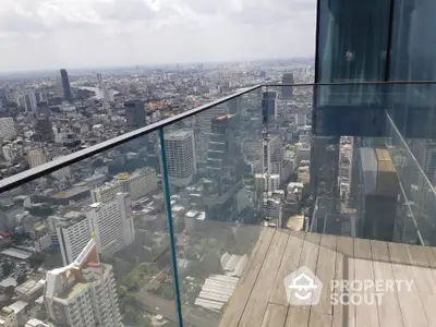 Stunning cityscape view from a modern glass balcony in a high-rise building.