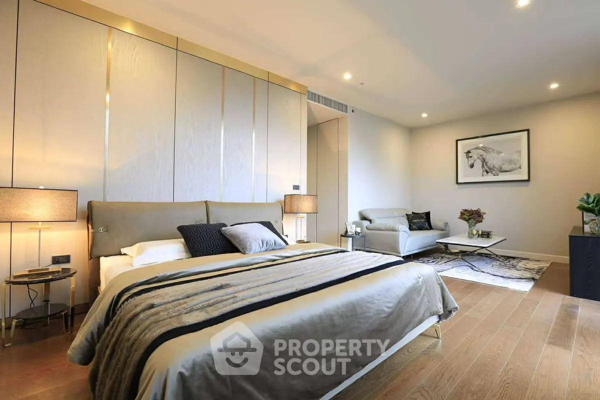 Luxurious modern bedroom with elegant decor and cozy seating area.