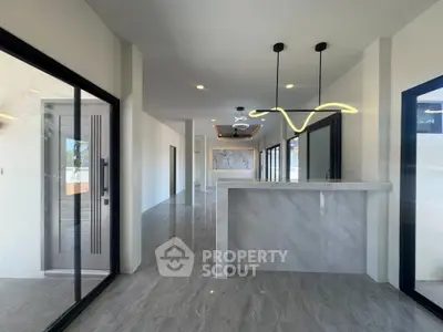 Modern open-plan living space with sleek lighting and marble flooring