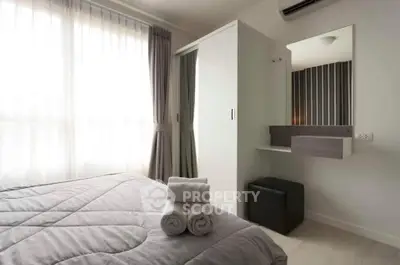 Modern bedroom with stylish decor and natural light, featuring a cozy bed and sleek wardrobe.