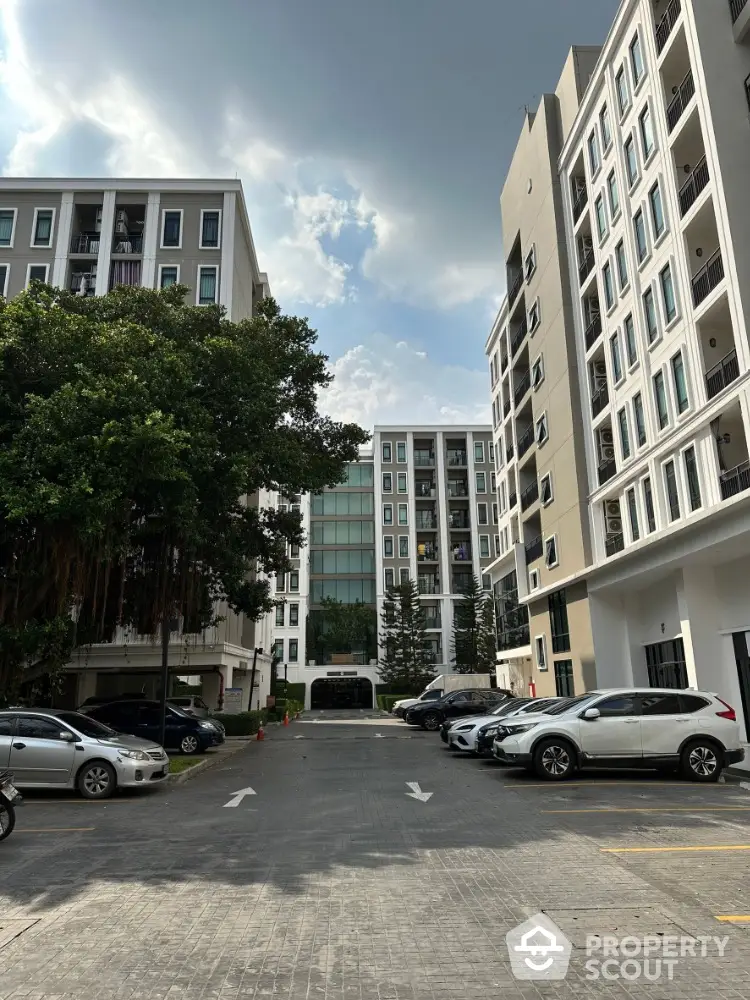 Modern apartment complex with parking and lush greenery