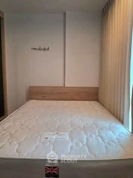 Cozy bedroom with a comfortable mattress and elegant curtains, perfect for restful nights.