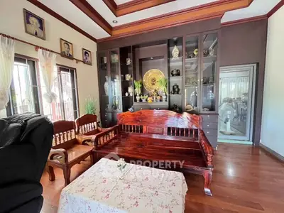 Elegant living room with wooden furniture and decorative shelving in a cozy home setting.