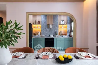 Stylish modern kitchen with open layout and elegant dining area, featuring sleek cabinetry and vibrant decor.