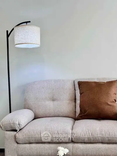 Cozy living room with modern sofa and stylish floor lamp, perfect for relaxation.