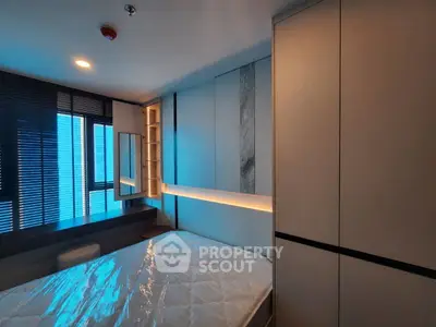 Modern bedroom with sleek design and ambient lighting, featuring built-in storage and large windows.