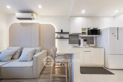 Modern open-layout kitchen and living room with sleek design and cozy seating area.