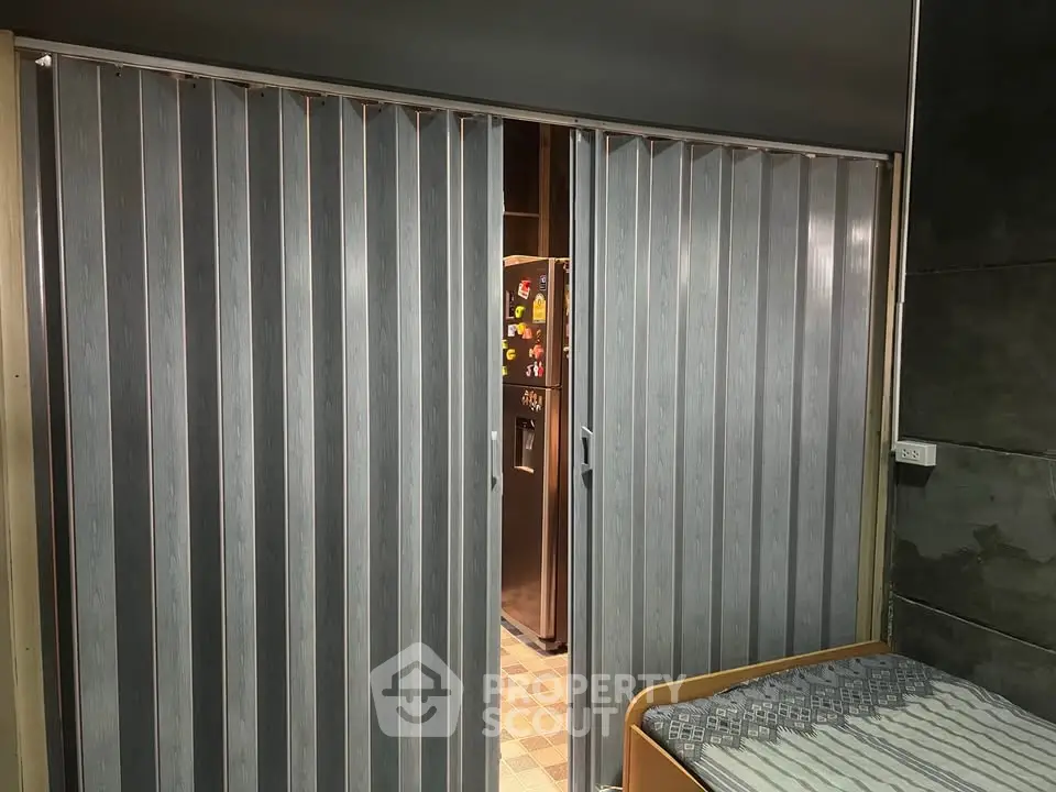 Cozy bedroom with sliding partition revealing modern kitchen area