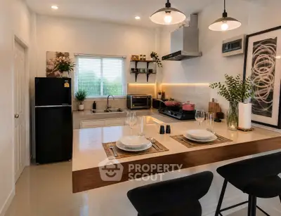 Modern kitchen with open layout, sleek appliances, and stylish breakfast bar seating.